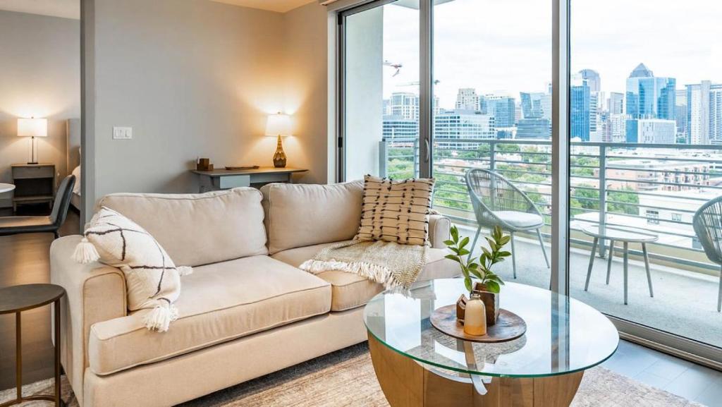 a living room with a couch and a glass table at Landing - Modern Apartment with Amazing Amenities (ID1513X37) in Dallas