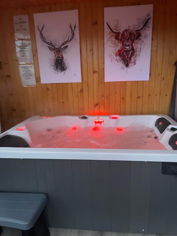 una bañera con dos cabezas de ciervo. en Ben Nevis Manor Lodge & Indoor Private Hot-Tub, en Fort William