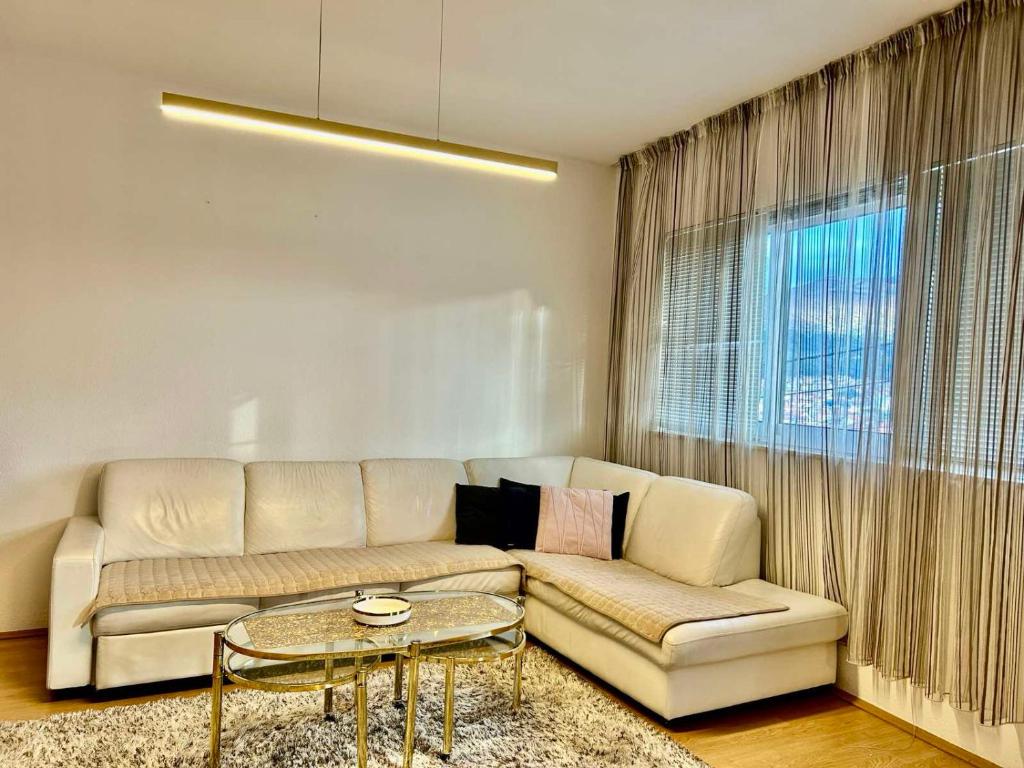 a living room with a couch and a table at Apartmani Andrić - Stylish & Peaceful Apartment with Free Parking - 10 min Walk to Old Town in Trebinje