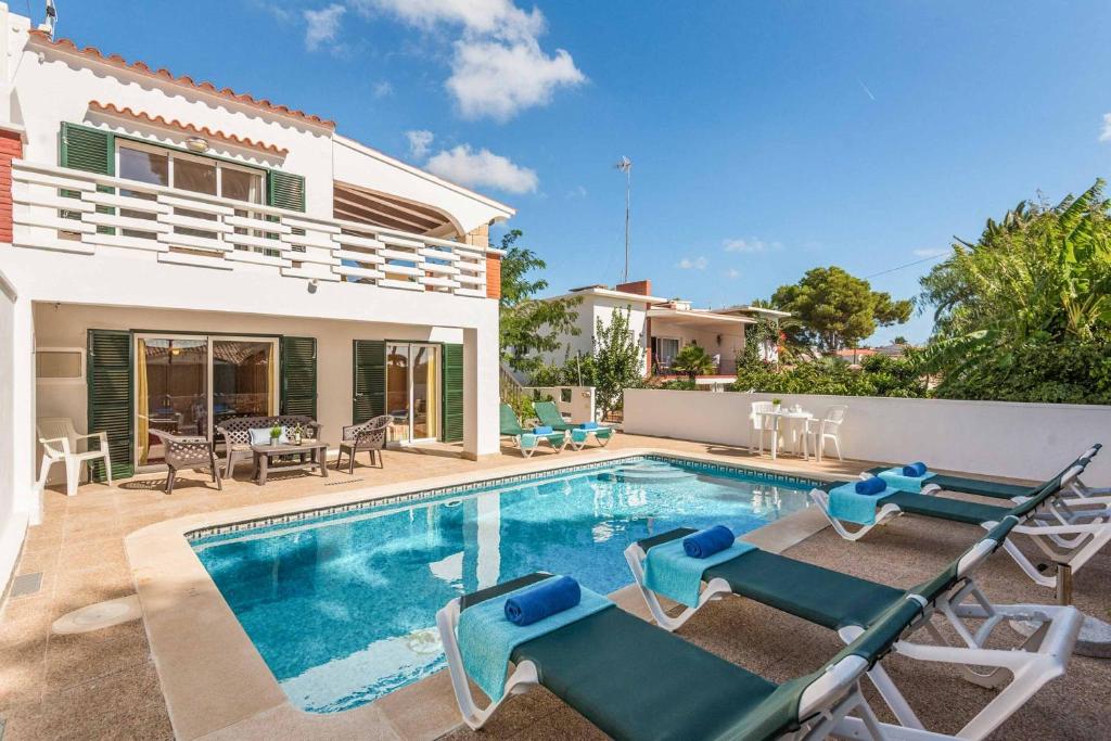 a villa with a swimming pool and a house at Villa Cati Punta Prima in Punta Prima