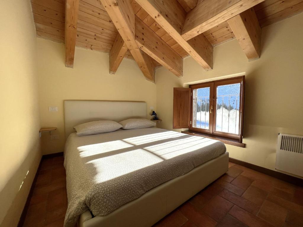 una camera con un grande letto in una stanza con finestra di Affittimoderni Ponte di Legno Ski a Ponte di Legno