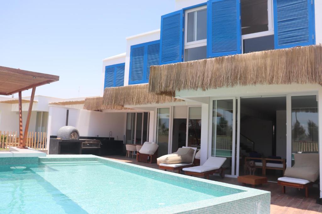 ein Haus mit Swimmingpool neben einem Gebäude in der Unterkunft Casa Z Paracas in Paracas
