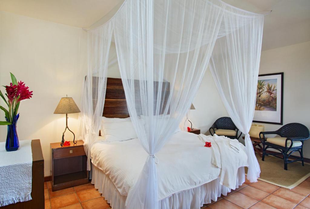 a bedroom with a white bed with a canopy at Victoria House Resort & Spa in San Pedro
