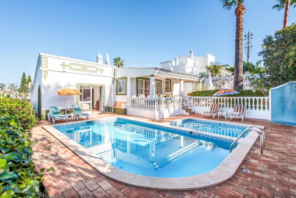 a swimming pool in front of a house at Villa Cardona in Guia