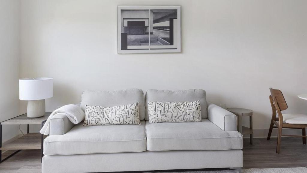 un sofá blanco en una sala de estar con mesa en Landing - Modern Apartment with Amazing Amenities (ID5286X10) en Richmond
