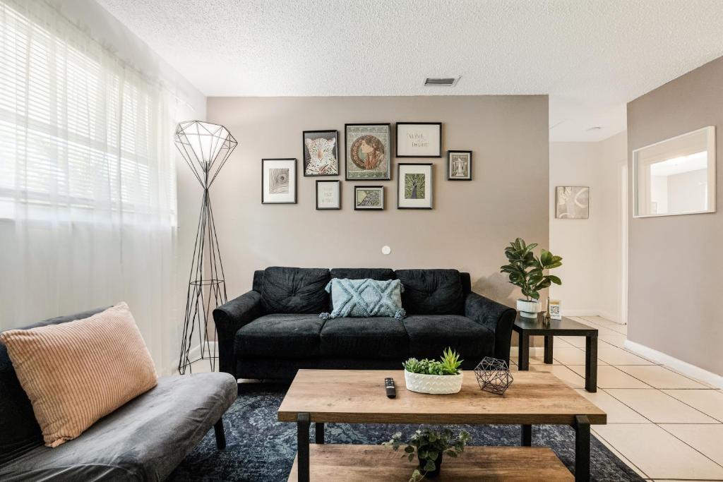 a living room with a black couch and a table at Stylish 2 Bedroom Apartment In The Heart Of Miami in Miami