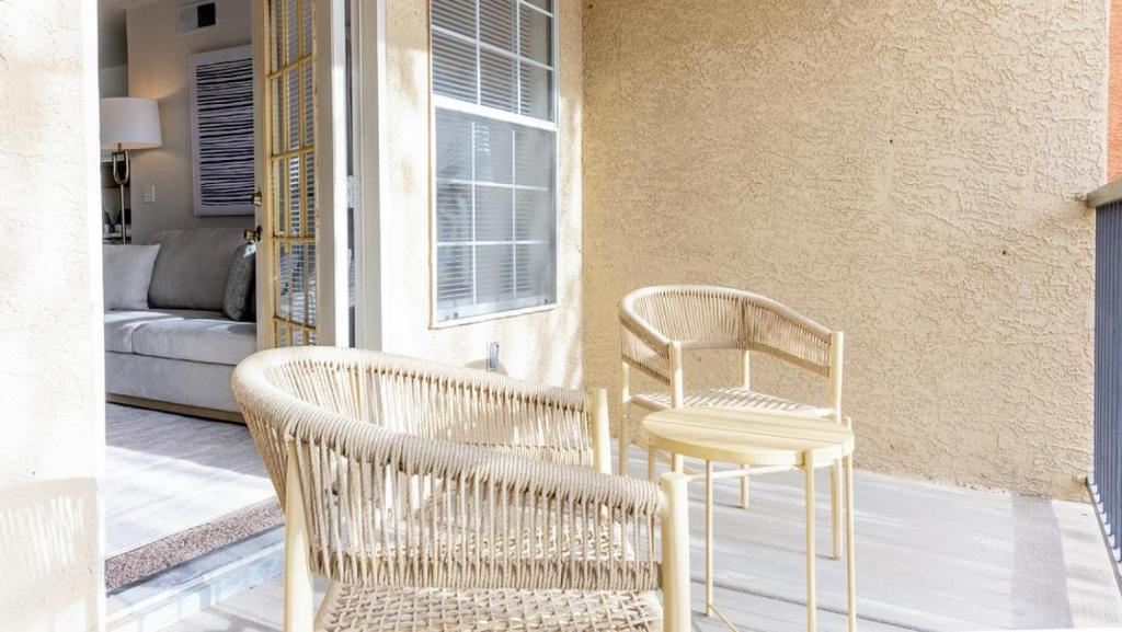 two wicker chairs and a table on a porch at Landing - Modern Apartment with Amazing Amenities (ID9354X35) in Albuquerque