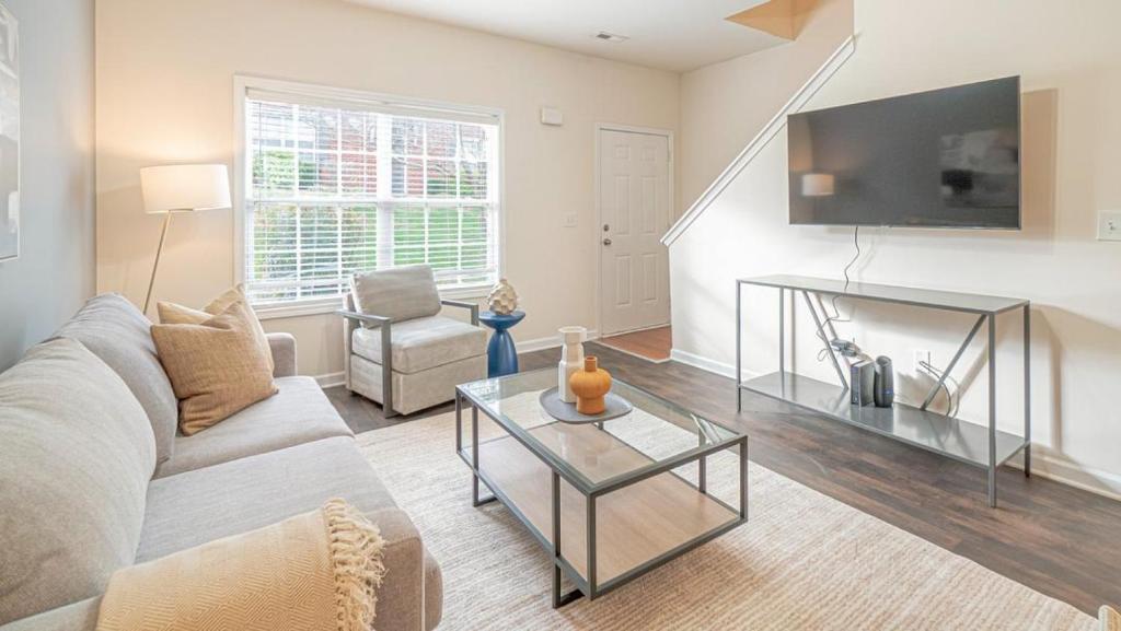un soggiorno con divano e tavolo di Landing - Modern Apartment with Amazing Amenities (ID7689X22) a Spring Hill