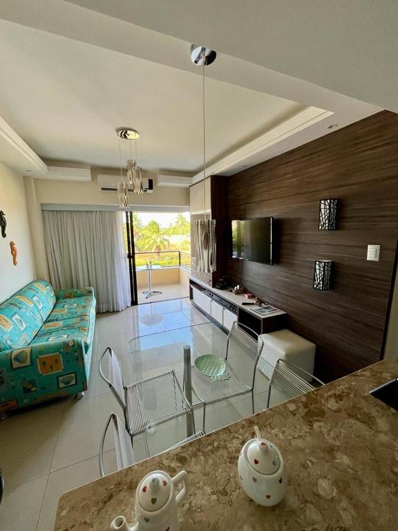 a living room with a glass table and a couch at Gavoa Resort Flat - Mar Doce Lar in Igarassu