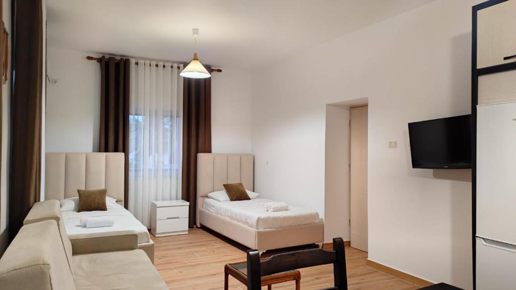 sala de estar con 2 camas y TV en Four Seasons Apartments, en Ksamil