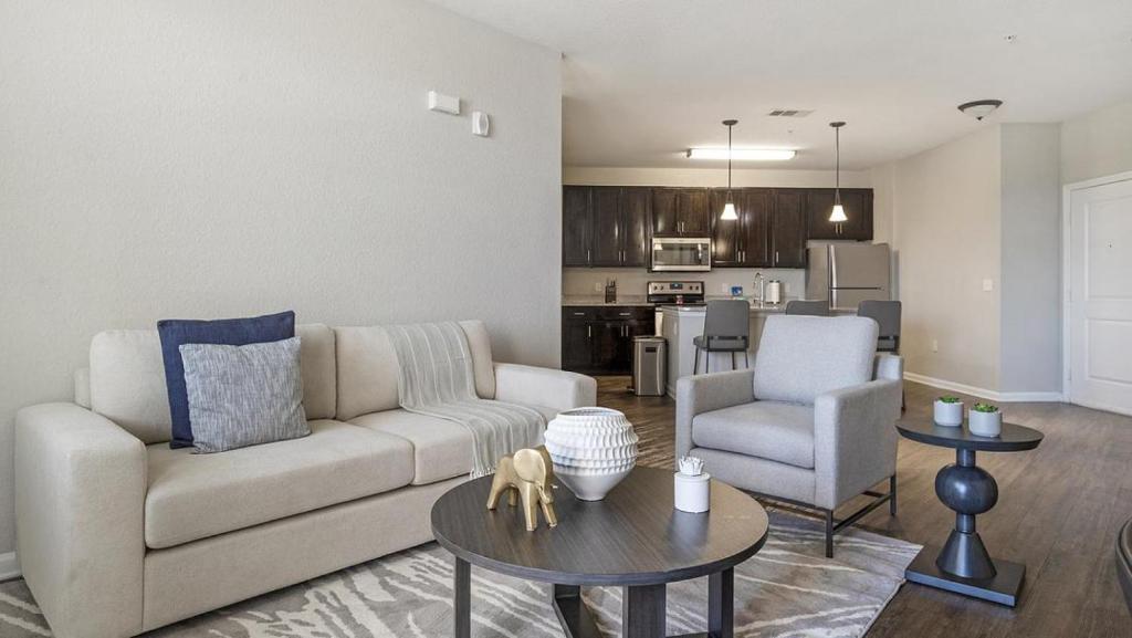 een woonkamer met een bank en een tafel bij Landing - Modern Apartment with Amazing Amenities (ID1192X099) in Kissimmee