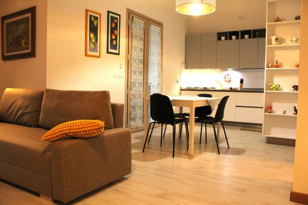 - un salon avec un canapé et une table avec des chaises dans l'établissement appartamento cuore del chianti, à Tavarnelle in Val di Pesa