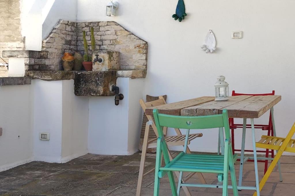 einen Holztisch und Stühle in einem Zimmer mit einer Wand in der Unterkunft Casa Mea in Grottaglie