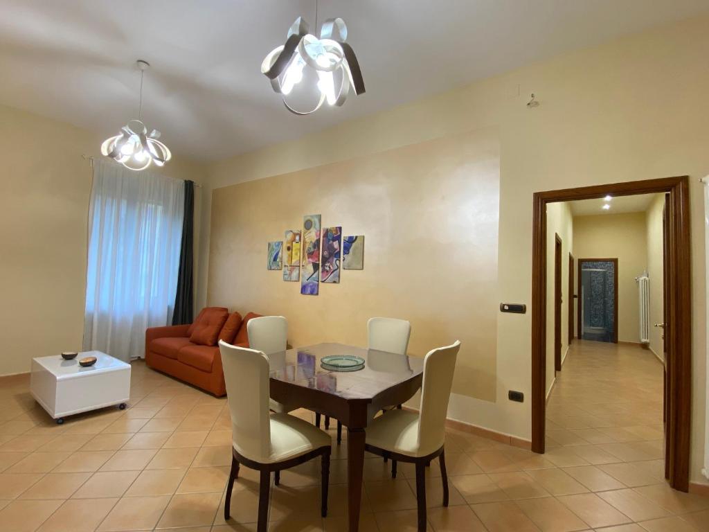 sala de estar con mesa, sillas y sofá en Gravina House, en Portici