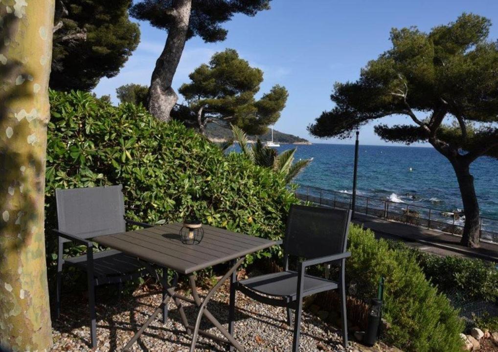 - une table de pique-nique et 2 chaises au bord de l'océan dans l'établissement Bel appartement 5 pers plage de Gigaro, à La Croix-Valmer
