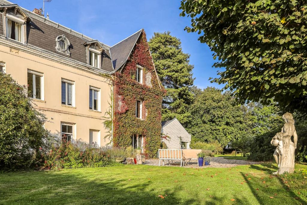 uma casa com hera a crescer ao lado dela em Dans maison de charme, bel appartement privatif em Saint-Laurent-de-Brévedent