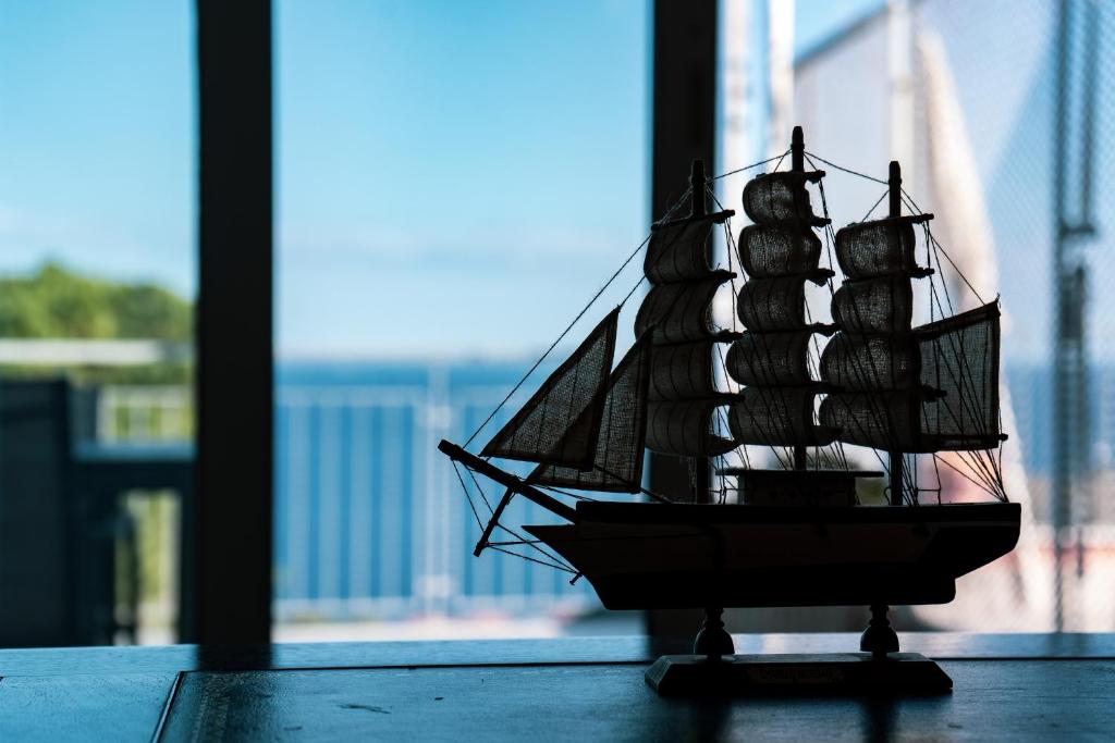 een kleine speelgoedboot op een tafel bij een raam bij Admiral's apartments in Aci Catena