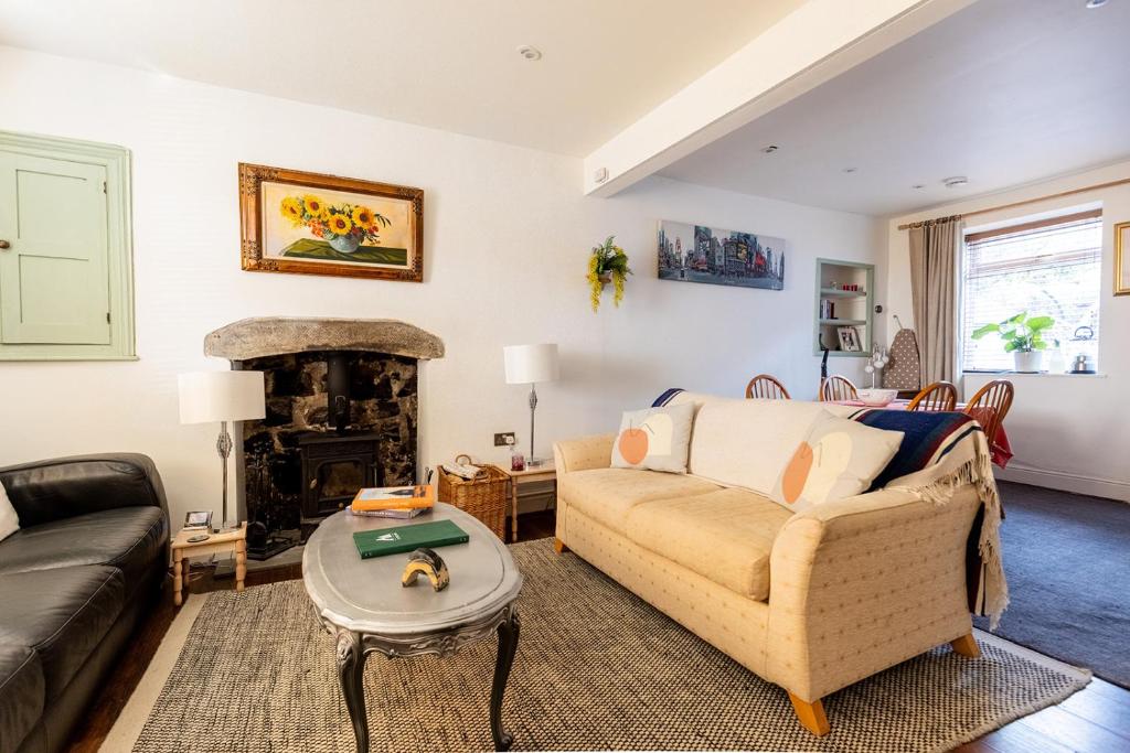 a living room with a couch and a fireplace at OAKERTHORPE COTTAGE - Countryside Cottage near the Peaks District National Park in Wirksworth