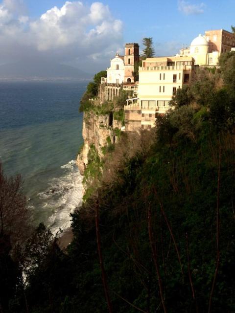 a building on top of a cliff next to the ocean at La solution 2023 in Vico Equense