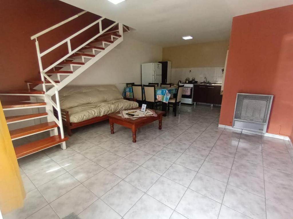 sala de estar con sofá y escalera de caracol en Lo de fernando 1, en Río Gallegos