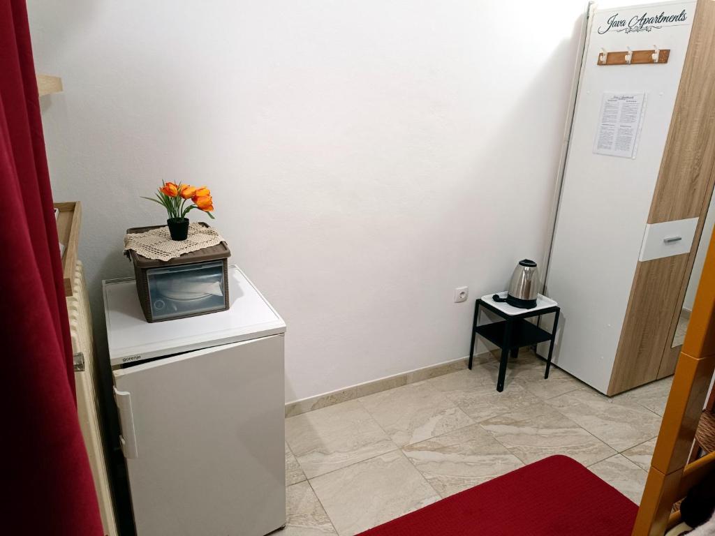um quarto com uma pequena televisão em cima de um frigorífico em Java apartments - S & J em Dobrota