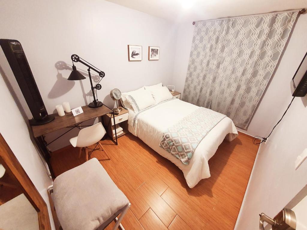 1 dormitorio con cama, escritorio y lámpara en Aeropuerto CDMX, foro sol, la casa de Leo, en Ciudad de México