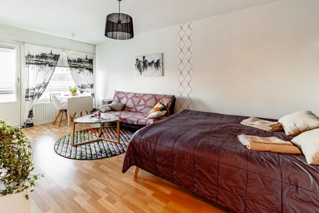 a bedroom with a bed and a couch at Central Studio Apartment in Pori