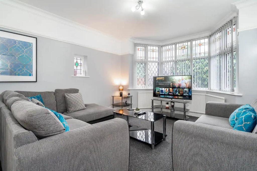 a living room with two couches and a flat screen tv at 5 Bedroom House - 11 Guests - Huge Driveway for Parking - 316C - Top Rated - Netflix - Wifi - Smart TV in Birmingham