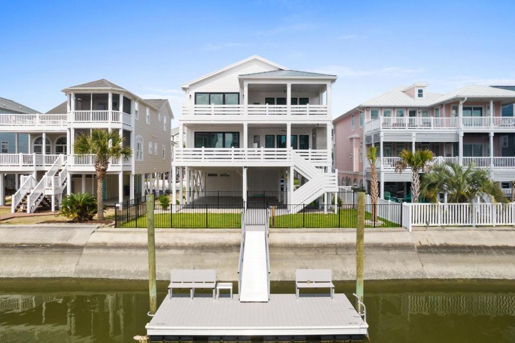 a house on the water with a dock in front at 25 Cumberland - Canal front with dock, Custom home finishes in Ocean Isle Beach