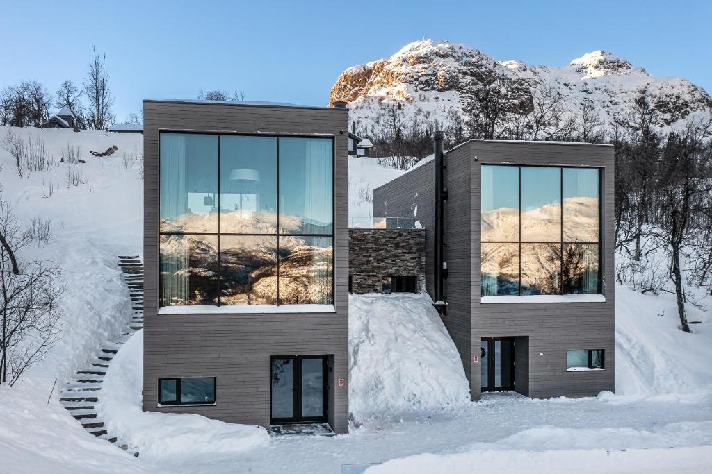 a house in the snow with mountains in the background at Tindekroken 5, Hemsedal in Fausko