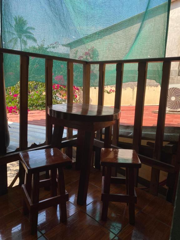 uma mesa e dois bancos numa varanda com vista em Hotel Pacific Surf AC Room Best in Tunco Beach em Tamanique