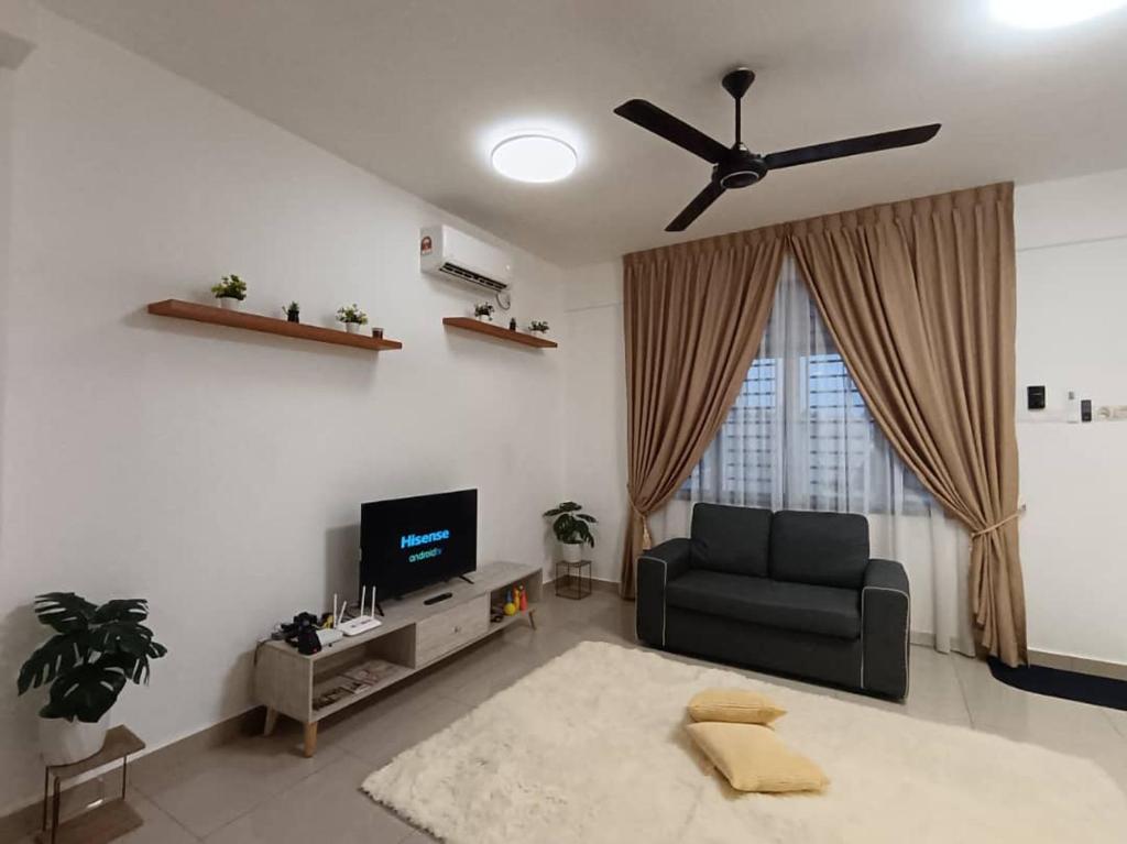 sala de estar con sofá y TV en DESARU SERENITA Homestay NETFLIX WIFI, en Bandar Penawar