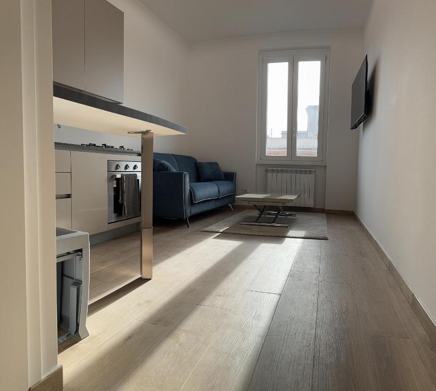 Una sala de estar con un sofá azul y una mesa. en San Lorenzo Luxury, en Roma