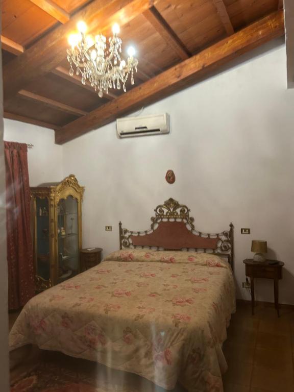 sypialnia z łóżkiem i żyrandolem w obiekcie Locanda verde w mieście Vaiano