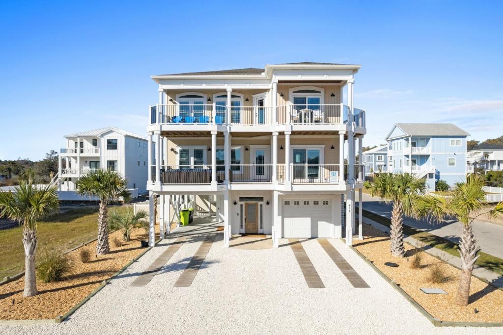a large white house with palm trees in front of it at All the Views Ocean Isle Beach, heated private pool, close to beach in Ocean Isle Beach