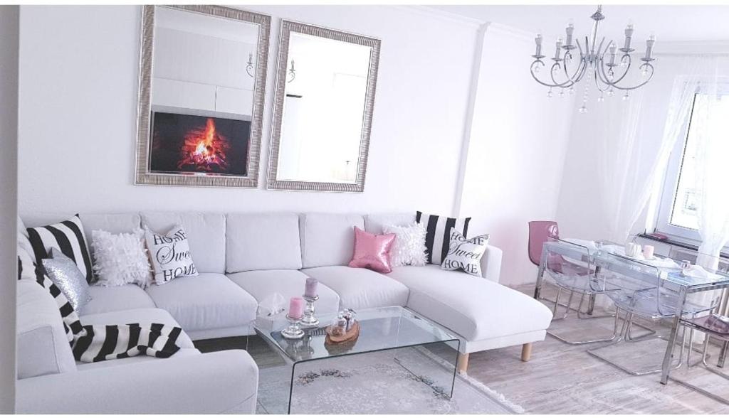 a living room with a white couch and a chandelier at Hannover City Suite in Hannover