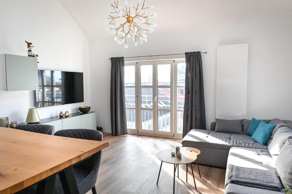 ein Wohnzimmer mit einem Sofa und einem Tisch in der Unterkunft Moderne Wohnung, citynah, mit Ausblick über die Stadt in Hannover