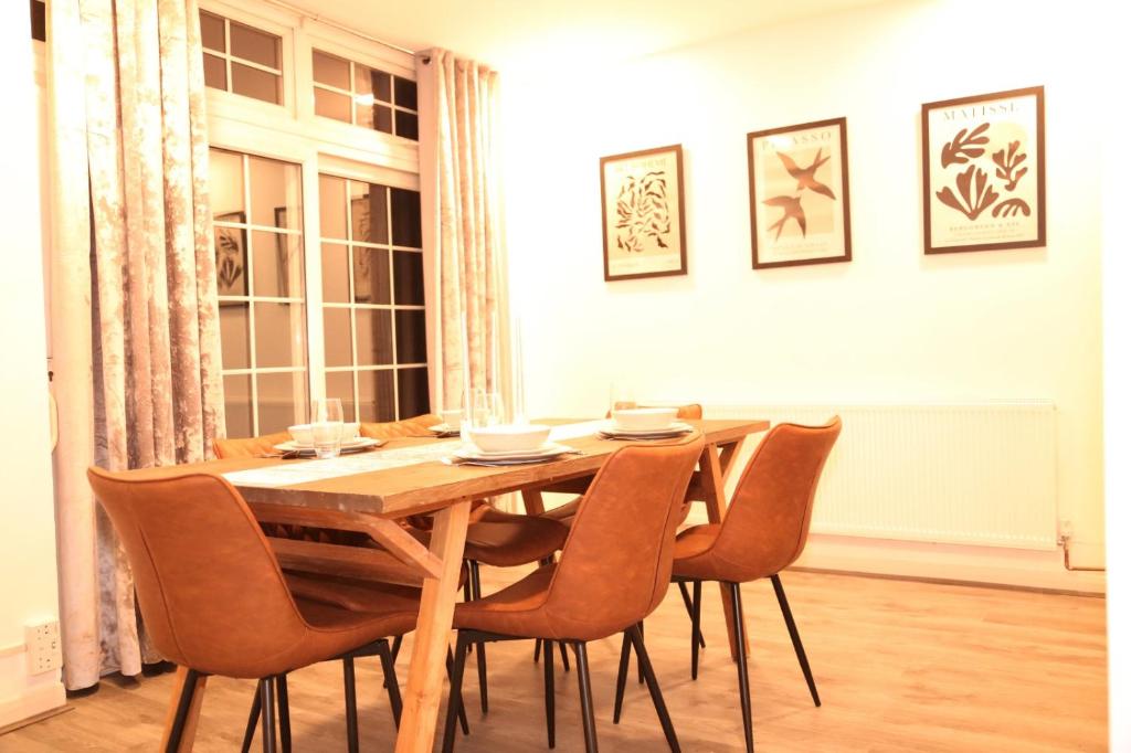 a wooden table and chairs in a room at Star London Golders Rise Luxury 4-Bed Oasis with Garden in Hendon