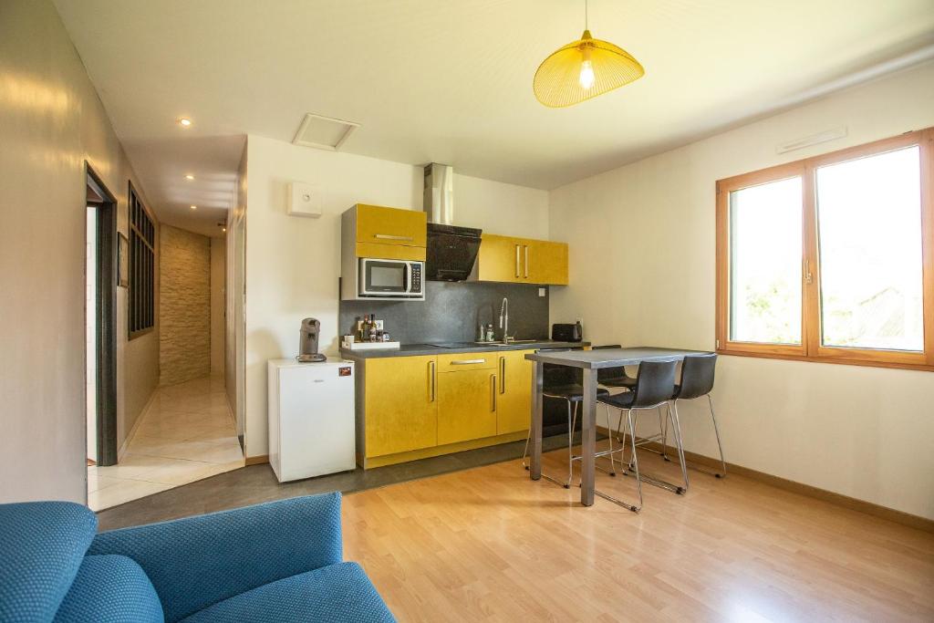una cucina con armadi gialli e un tavolo in una stanza di Maison calme, près du puy du fou a La Gaubretière