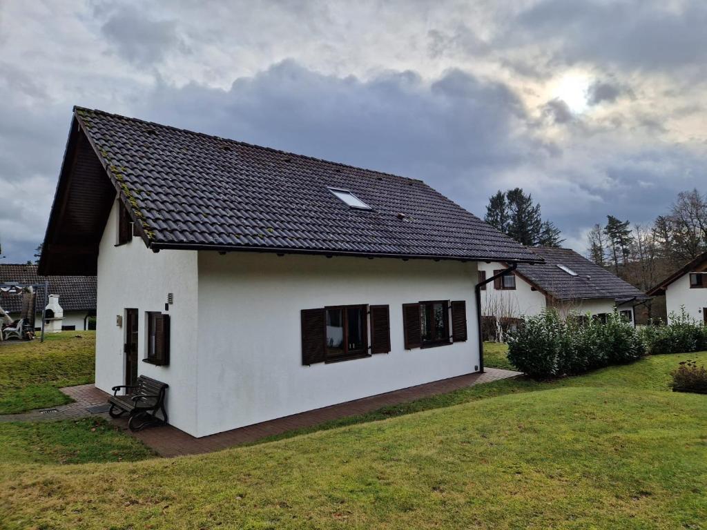 una casa blanca con techo negro en Ferienhaus im Seepark von Kirchheim en Kirchheim