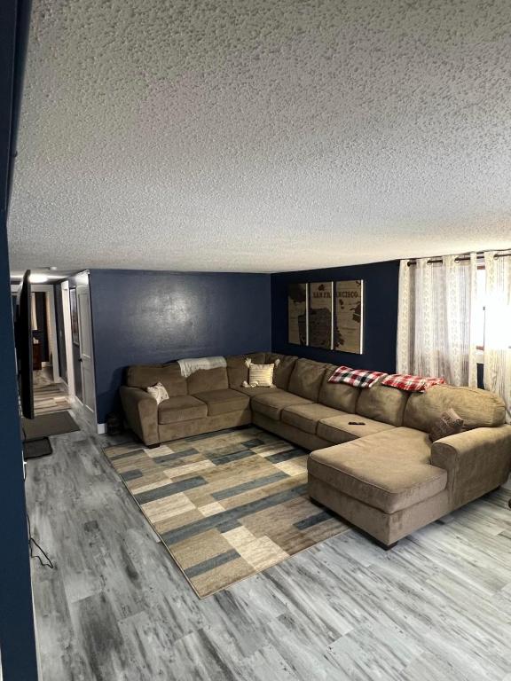 a living room with a large couch and blue walls at Entire level just off Interstate, free breakfast in Fargo
