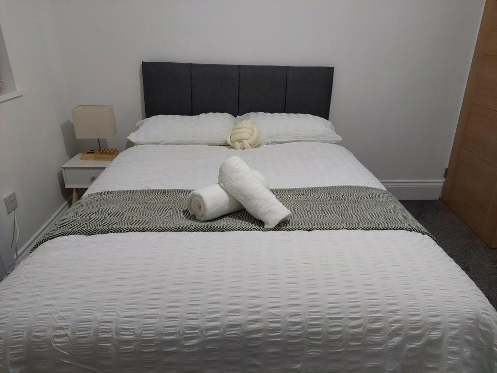 uma cama com duas almofadas em cima em Guest Apartments em Redditch