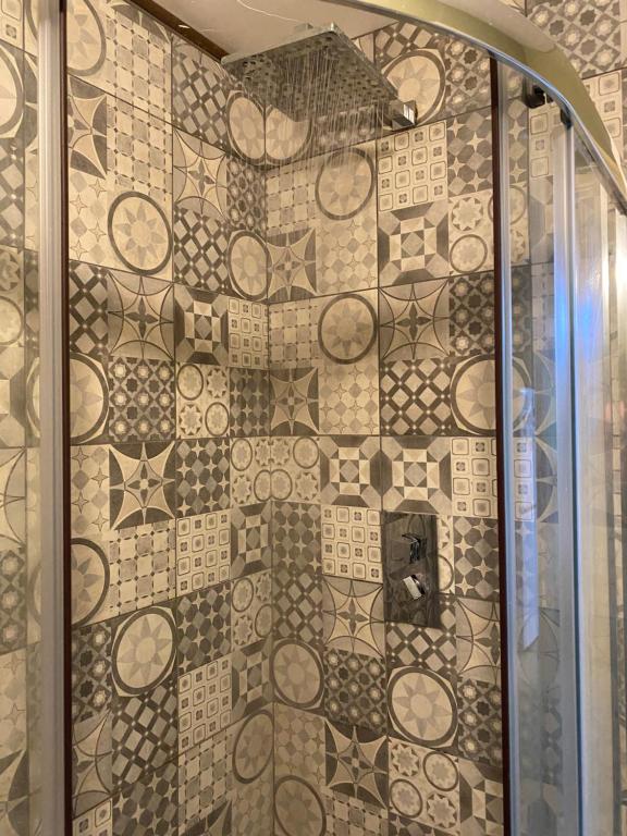 a shower with a tiled wall in a bathroom at The Hardy Room in Windsor