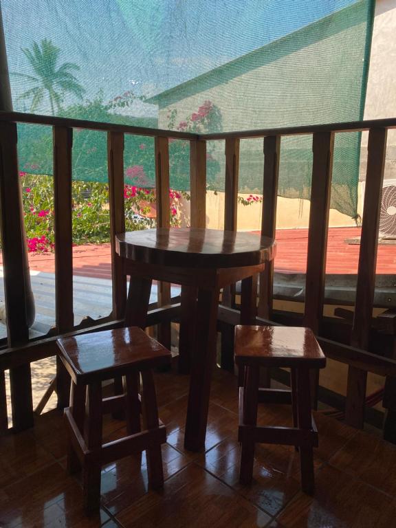 a table and two stools on a balcony with a view at Hotel Pacific Surf Room with AC best place in Tunco in Tamanique