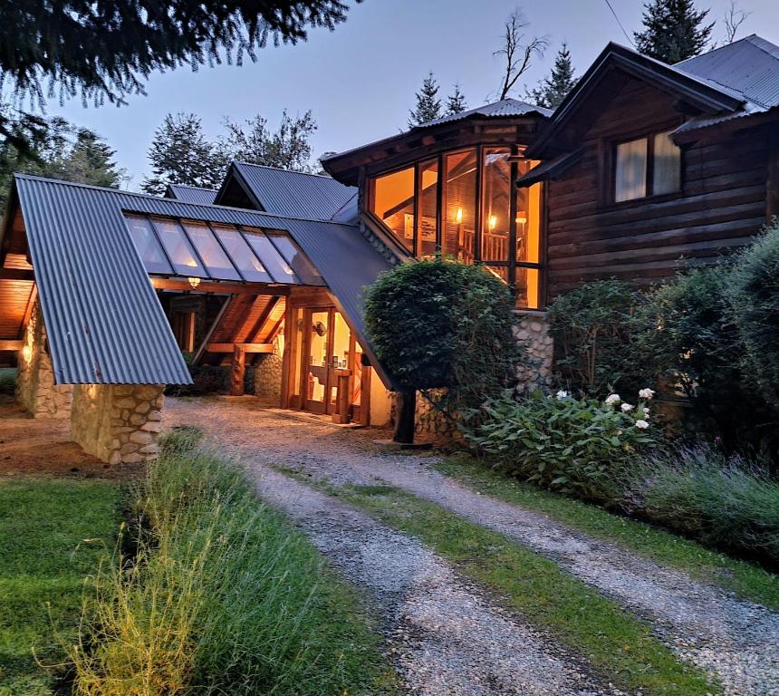 una gran casa de madera con muchas ventanas en Altos Los Pioneros & Spa en Villa La Angostura