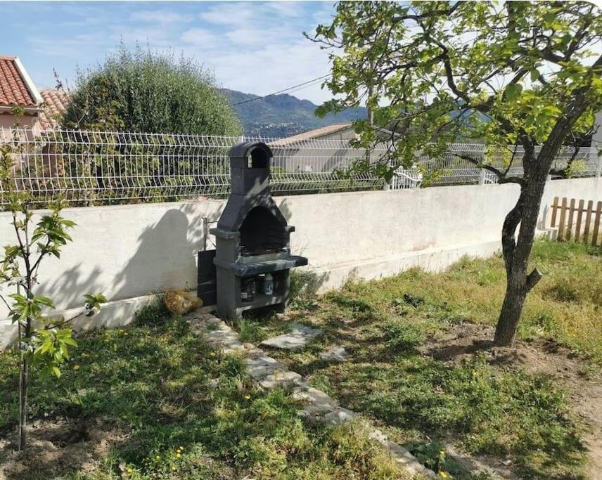 un forno per pizza seduto accanto a un muro di Appartement entre mer et montagne avec beau jardin a Calenzana