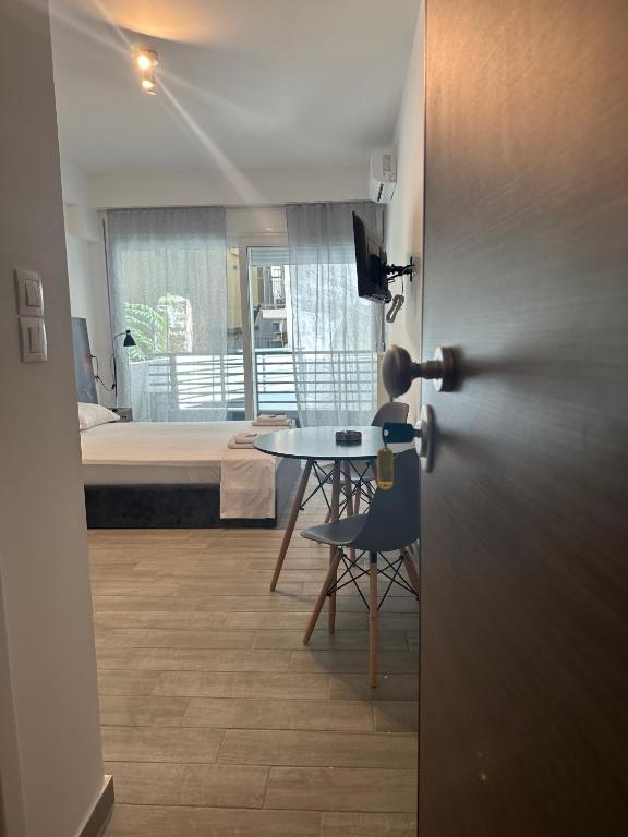 a room with a table and a bed and a table and chairs at Brand new studios IPM1-2-3-4 in Larisa