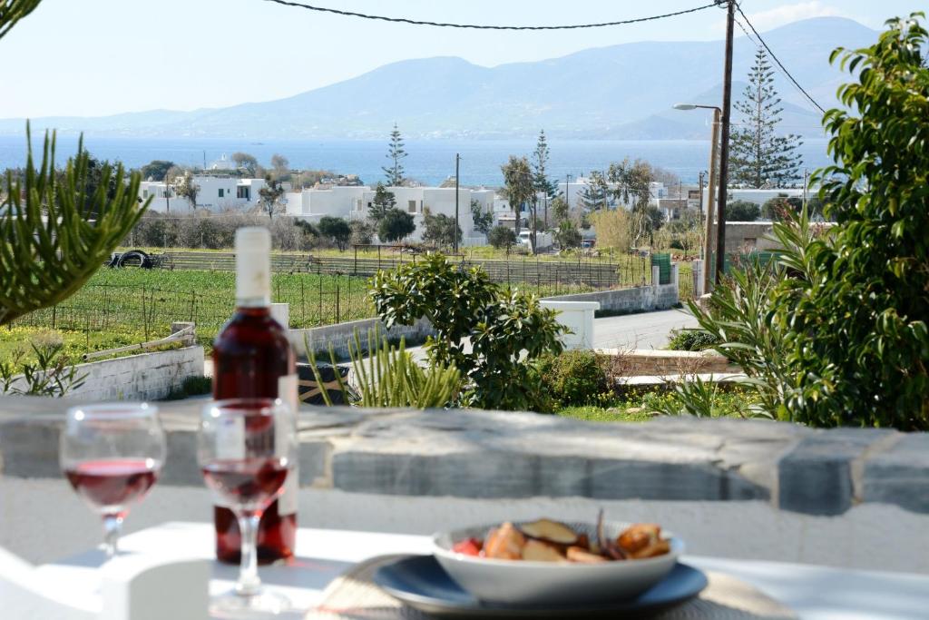 a bottle of wine and a plate of food on a table at Aegean White Aparts in Naxos Chora
