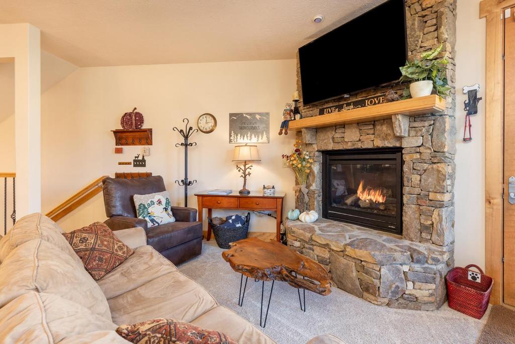 a living room with a stone fireplace with a flat screen tv at Southwinds Ultimate Slope Side Relaxation Spot in Champion