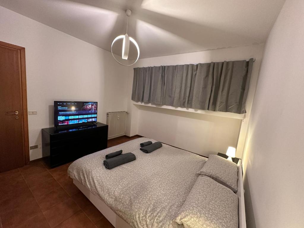 a bedroom with a bed and a flat screen tv at ROMA HOME in Udine